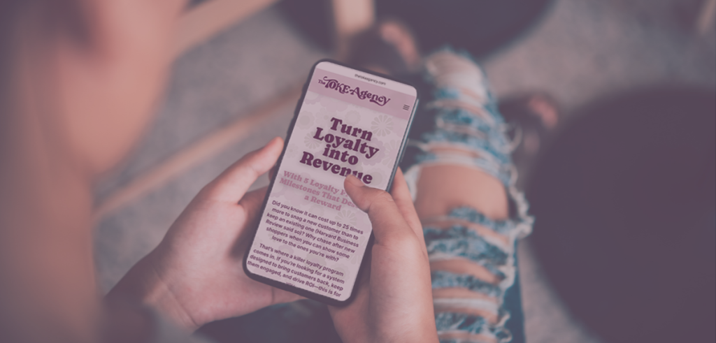 Person holding a smartphone displaying The TOKE Agency blog post “Turn Loyalty Into Revenue,” illustrating cannabis dispensary loyalty marketing on a mobile device.